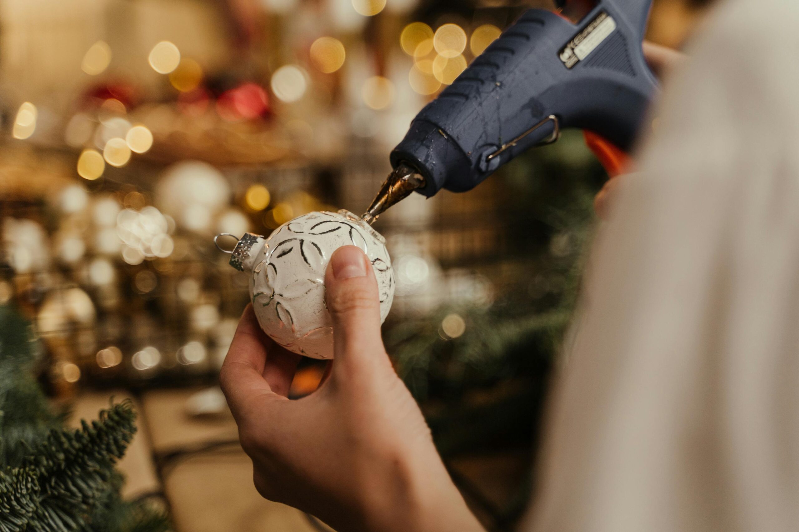 boule de noël blanche avec pistolet à colle